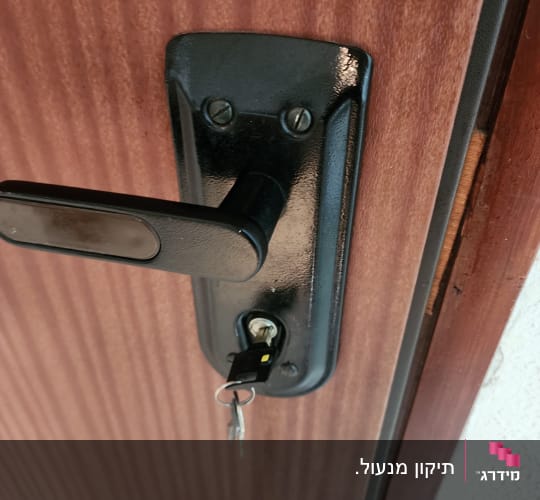 מנעול עם מפתח בדלת עץ